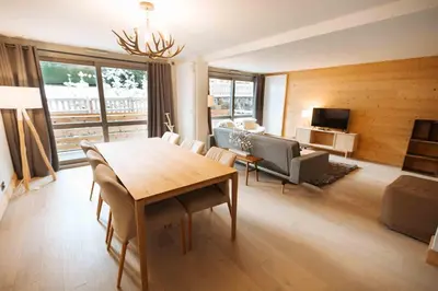a living room with a dining room table and a couch at Residence Lesporting Ski – Megeve – АW201 in Megève