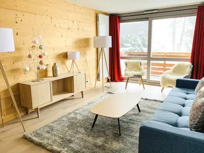 a living room with a blue couch and a table at Residence Lesporting Ski – Megeve – АW201 in Megève