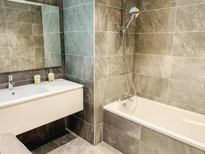 a bathroom with a tub and a sink and a toilet at Residence Lesporting Ski – Megeve – АW201 in Megève