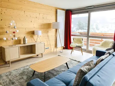 a living room with a blue couch and a table at Residence Lesporting Ski – Megeve – АW201 in Megève