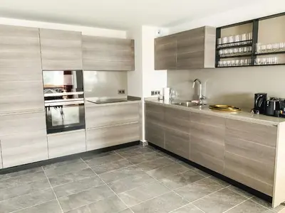 a kitchen with wooden cabinets and a tile floor at Residence Lesporting Ski – Megeve – АW201 in Megève