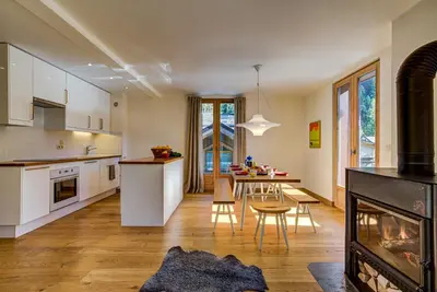 an open kitchen and dining room with a fireplace at Villa Mont Blanc in Chamonix-Mont-Blanc