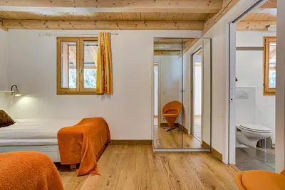 a bedroom with a bed and a toilet and a mirror at Villa Mont Blanc in Chamonix-Mont-Blanc