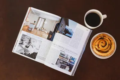 a magazine with a cup of coffee and a pastry at Villa Mont Blanc in Chamonix-Mont-Blanc