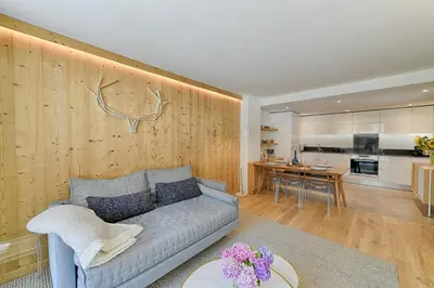 a living room with a couch and a kitchen at The Drus Luxury Apartment with Spa and Indoor Pool in Chamonix-Mont-Blanc