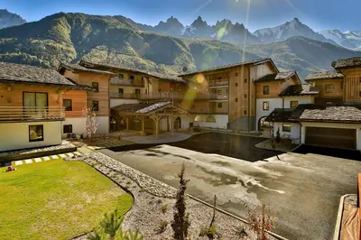 a group of buildings with mountains in the background at The Drus Luxury Apartment with Spa and Indoor Pool in Chamonix-Mont-Blanc