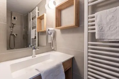 a bathroom with a sink and a phone on the wall at AEC Village Vacances - Les Becchi in Samoëns