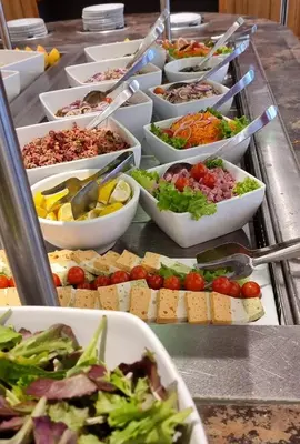 a buffet line with many bowls of different types of food at AEC Village Vacances - Les Becchi in Samoëns