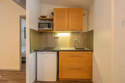 a small kitchen with wooden cabinets and a sink at Apartment Lognan 6 Centre Chamonix Mont Blanc in Chamonix-Mont-Blanc