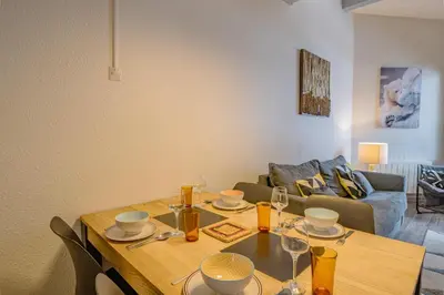 a dining room table with wine glasses and a couch at Apartment Lognan 6 Centre Chamonix Mont Blanc in Chamonix-Mont-Blanc