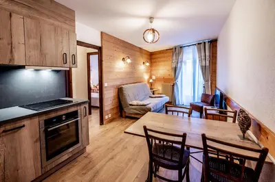 a kitchen and living room with a table and chairs at Maison Salina in Samoëns
