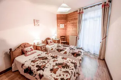 a bedroom with two beds and a window at Maison Salina in Samoëns