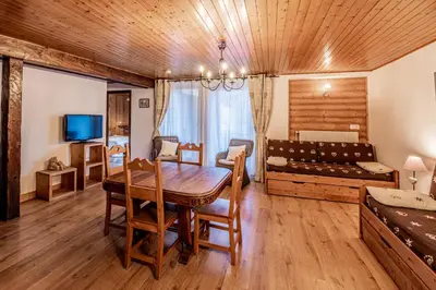 a dining room with a table and a bed in a room at Maison Salina in Samoëns