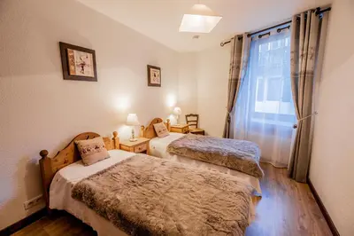 a bedroom with two beds and a window at Maison Salina in Samoëns