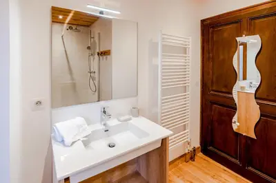 a bathroom with a white sink and a mirror at Maison Salina in Samoëns