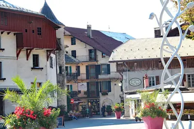 a group of buildings in a town with a statue at Maison Salina in Samoëns