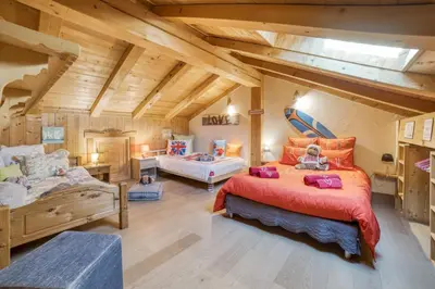 a bedroom with two beds and a couch at Le CHALAY in Les Carroz d'Araches