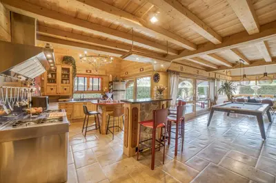 a kitchen with wooden ceilings and a table with chairs at Le CHALAY in Les Carroz d'Araches