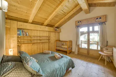a bedroom with a bed and a wooden ceiling at Le CHALAY in Les Carroz d'Araches