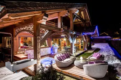 a house with a deck with purple pillows at Le CHALAY in Les Carroz d'Araches