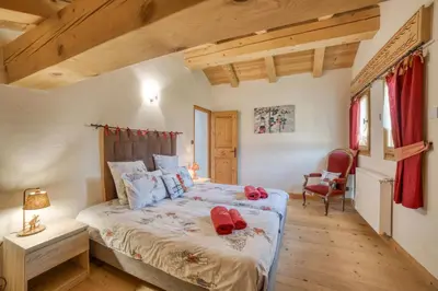 a bedroom with a bed with red shoes on it at Le CHALAY in Les Carroz d'Araches
