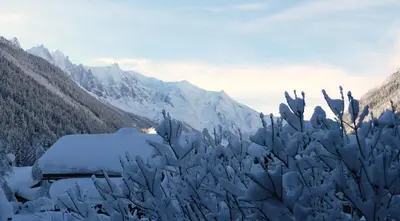 a truck covered in snow with mountains in the background at Appartement Capucine in Chamonix-Mont-Blanc