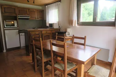a kitchen with a wooden dining room table and chairs at Appartement Capucine in Chamonix-Mont-Blanc