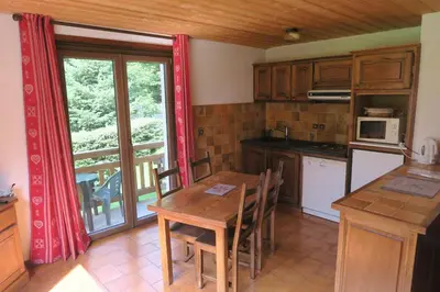 a kitchen with a wooden table and a dining room at Appartement Capucine in Chamonix-Mont-Blanc