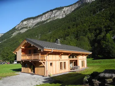 a cabin with snow on the roof in front of a mountain at LE DARMA in Sixt
