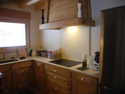 a kitchen with wooden cabinets and a sink and a window at LE DARMA in Sixt