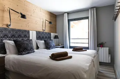 a bedroom with a large bed with two towels on it at La Cordee 331 Apartment in Chamonix-Mont-Blanc