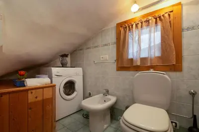 a bathroom with a toilet and a washing machine at Appartement Beauregard 1 - Happy Rentals in Les Houches