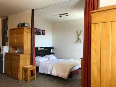 a bedroom with a bed and a wooden cabinet at Les Cimes in Samoëns