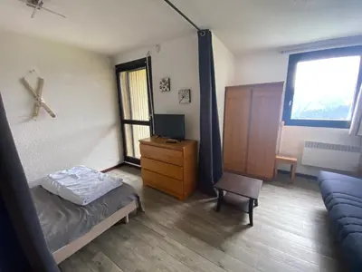 a bedroom with a bed and a tv and a chair at Les Cimes in Samoëns