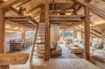 a log cabin living room with wooden ceilings at Chalet Les Meuniers in Megève