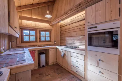 a kitchen with wooden cabinets and a stove top oven at Chalet Les Meuniers in Megève