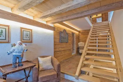 a room with a wooden staircase in a house at Chalet Les Meuniers in Megève