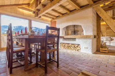 a dining room with a table and a fireplace at Chalet Les Meuniers in Megève