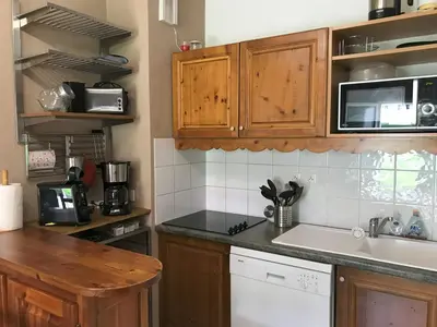 a kitchen with wooden cabinets and a white sink at Appartement T2+cabine indépendante au départ des télécabines Saint-Gervais/Bettex/Mont d’Arbois in Saint-Gervais-les-Bains