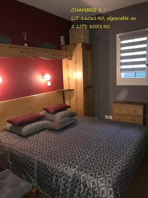 a bedroom with a large bed with a wooden headboard at Appartement T2+cabine indépendante au départ des télécabines Saint-Gervais/Bettex/Mont d’Arbois in Saint-Gervais-les-Bains