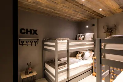 two bunk beds in a room with wooden ceilings at Chalet Seren in Chamonix-Mont-Blanc