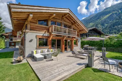 a log house with a deck and a patio at Chalet Seren in Chamonix-Mont-Blanc