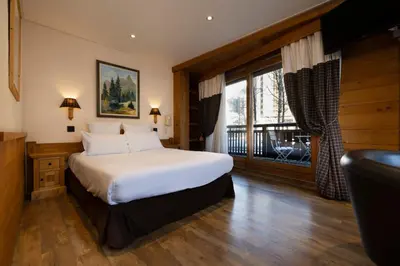a kitchen with a wooden table and a refrigerator at Hôtel de L'Arve by HappyCulture in Chamonix-Mont-Blanc