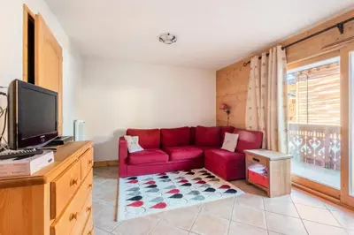 a living room with a red couch and a tv at Appartement 3 pièces 6 pers proche pistes - maeva Home - 3 Pièces 6 Personnes Sélection MAE-4880 in Arâches-la-Frasse