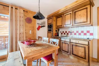 a kitchen with a wooden table and chairs at Appartement 3 pièces 6 pers proche pistes - maeva Home - 3 Pièces 6 Personnes Sélection MAE-4880 in Arâches-la-Frasse