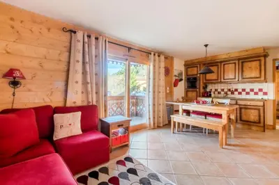 a living room with a red couch and a kitchen at Appartement 3 pièces 6 pers proche pistes - maeva Home - 3 Pièces 6 Personnes Sélection MAE-4880 in Arâches-la-Frasse