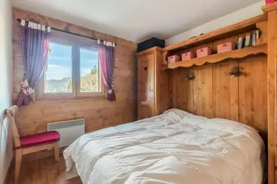 a bedroom with a bed and a window at Appartement 3 pièces 6 pers proche pistes - maeva Home - 3 Pièces 6 Personnes Sélection MAE-4880 in Arâches-la-Frasse
