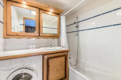 a bathroom with a washing machine and a sink at Appartement 3 pièces 6 pers proche pistes - maeva Home - 3 Pièces 6 Personnes Sélection MAE-4880 in Arâches-la-Frasse