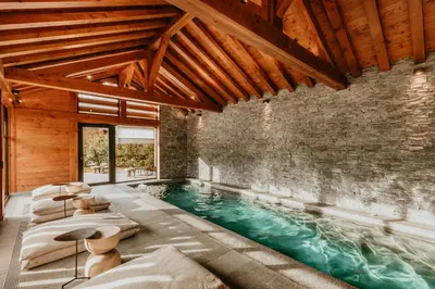 an indoor pool with chairs and a brick wall at Hôtel Restaurant La Ferme de Cupelin in Saint-Gervais-les-Bains