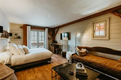a bedroom with a bed and a couch and a table at Hôtel Restaurant La Ferme de Cupelin in Saint-Gervais-les-Bains